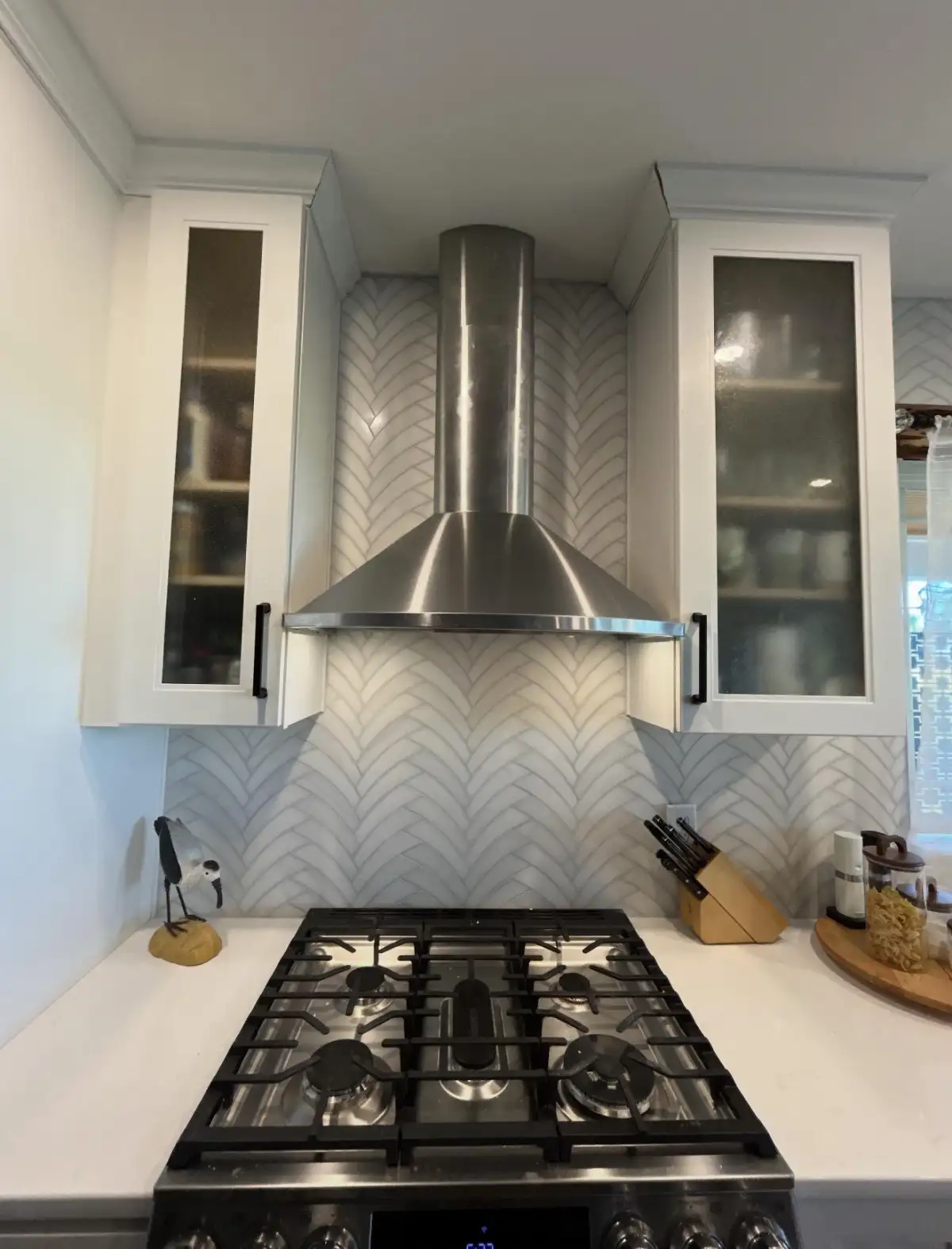 Herringbone chevron kitchen backsplash with glass cabinets