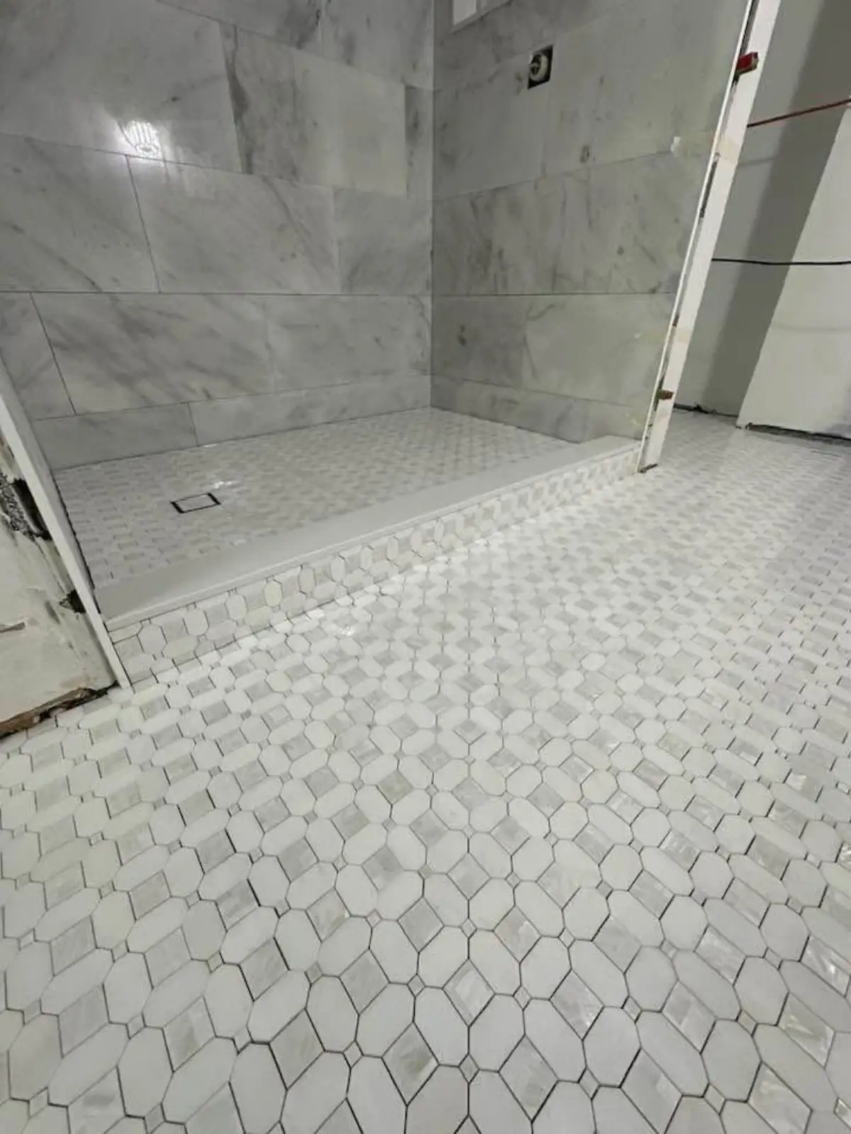 Large-format porcelain tile being installed on bathroom floor in Arlington TX