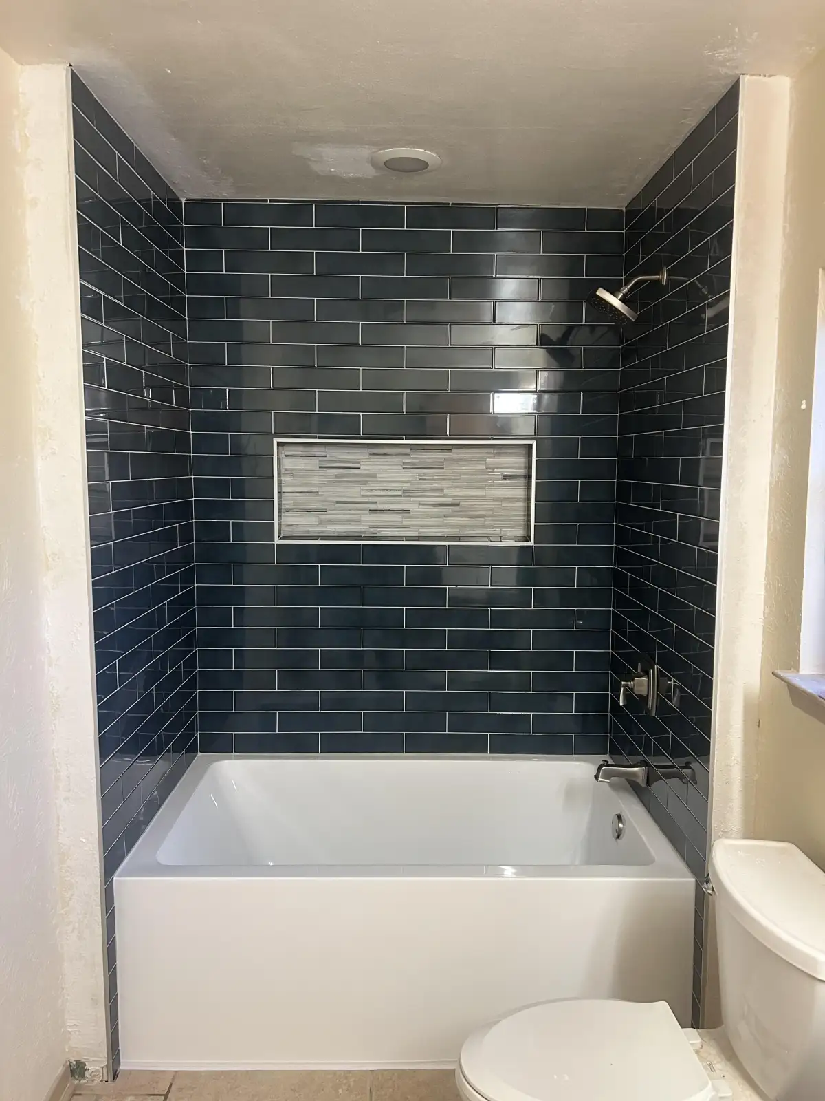 Completed tub to shower conversion with large-format tile and niche in Arlington